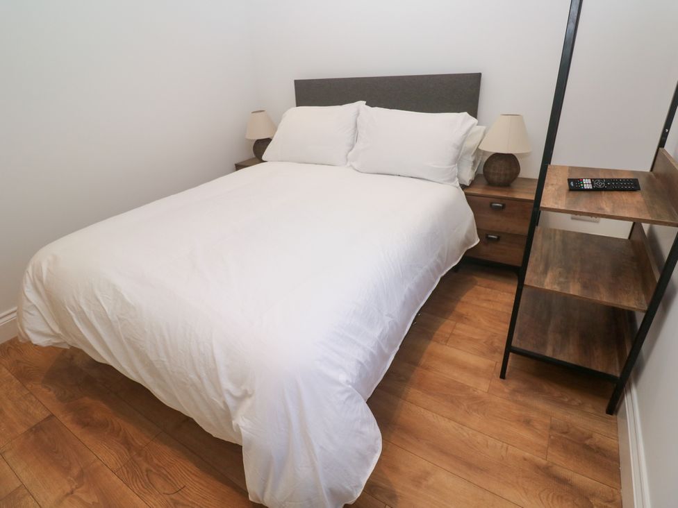 A bedroom with a bed and a nightstand at Gews Farm Lodge St Just