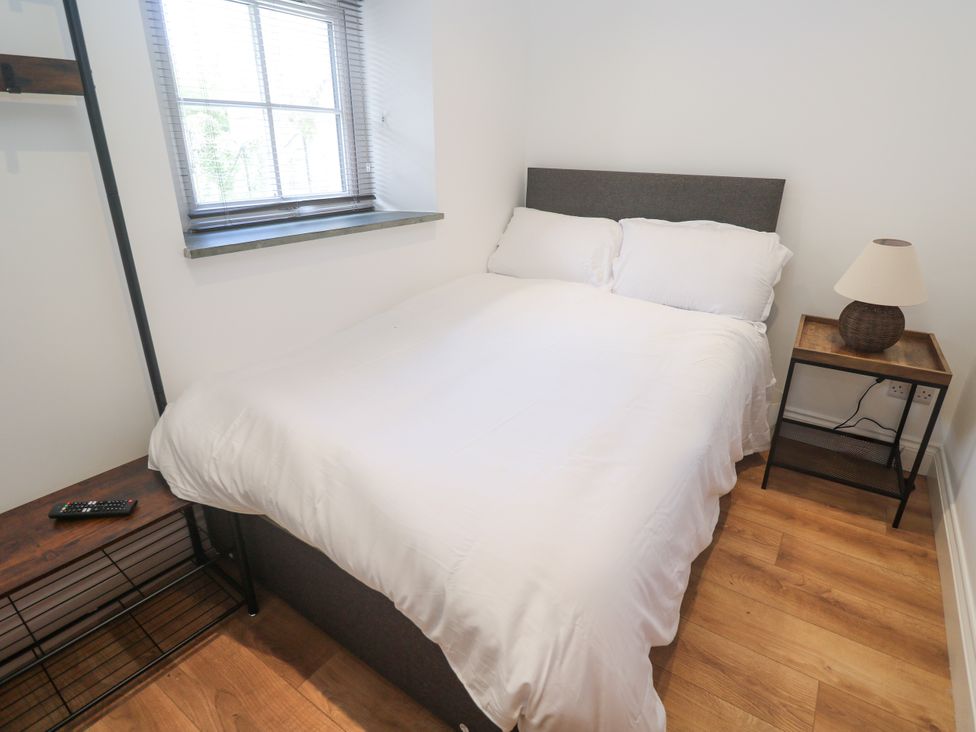 A bedroom with a bed and bedside table at Gews Farm Lodge in St Just
