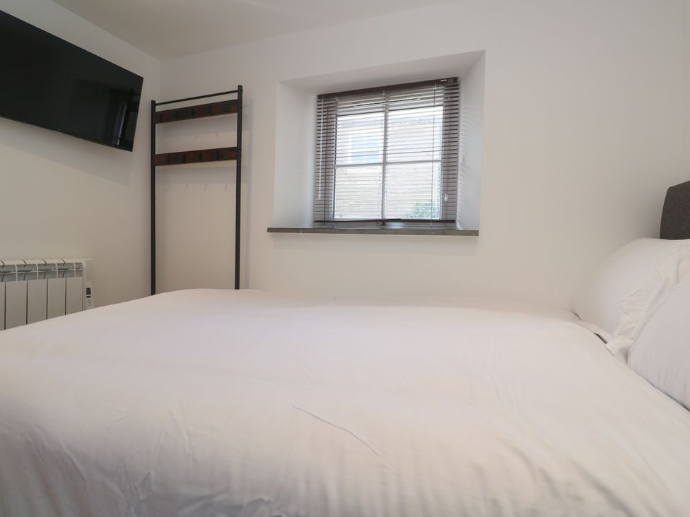 A bedroom with a bed and shelf at Gews Farm Lodge St Just