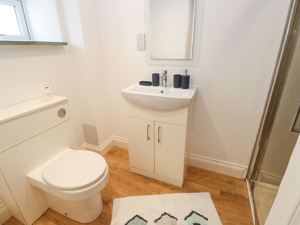 A bathroom with a sink, toilet, and shower at Gews Farm Lodge in St Just