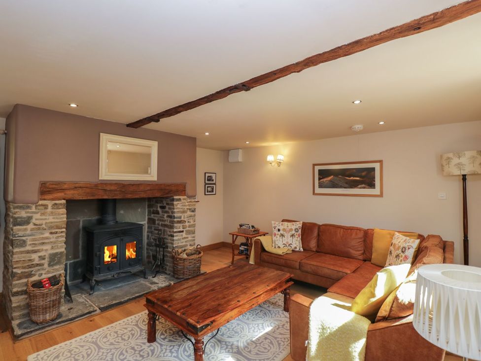 A living room with a fireplace and sofa at The Old Barn in Hereford