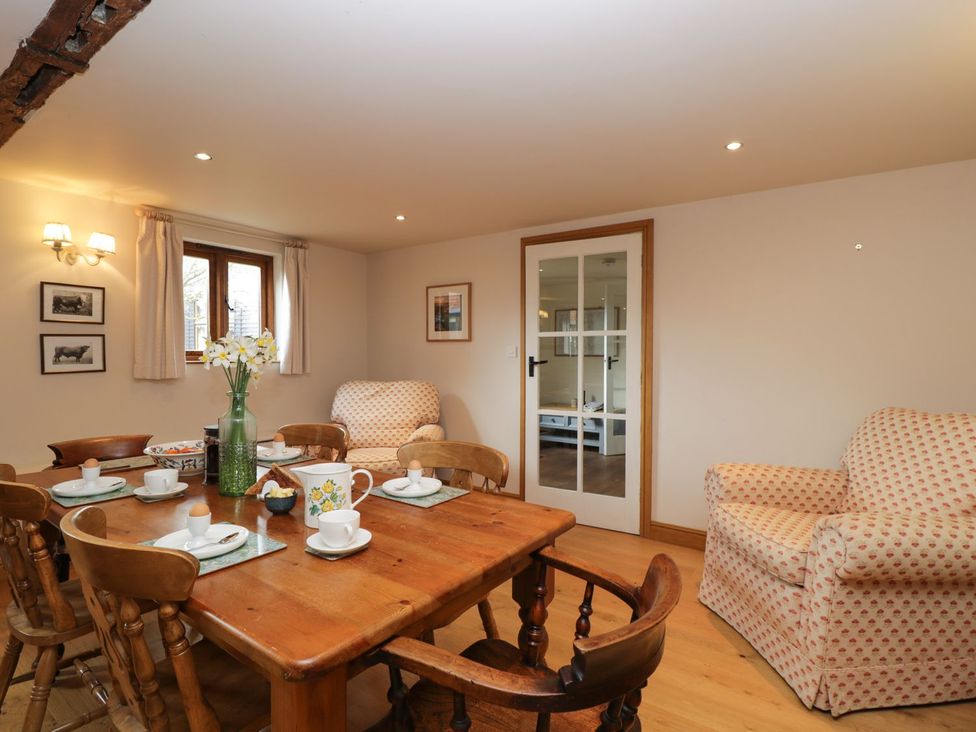 A dining room with a table, chairs and a sofa at The Old Barn in Hereford