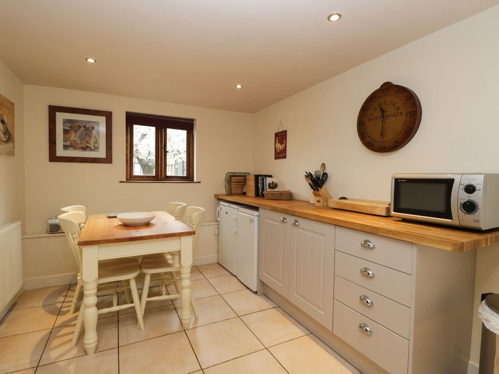 A kitchen with a table and chairs at The Old Barn in Hereford