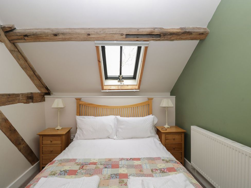 A bedroom with a bed and bedside tables at The Old Barn in Hereford