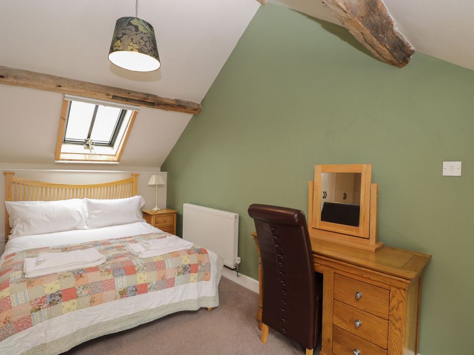 A bedroom with a bed and dressing table at The Old Barn in Hereford
