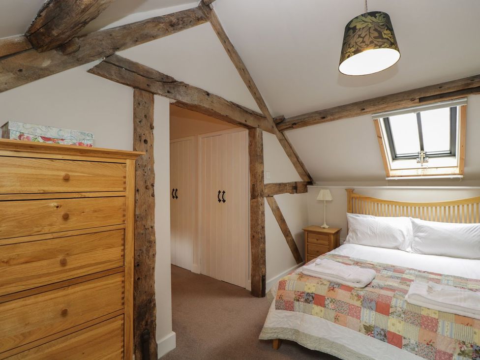 A bedroom with a bed and a drawer unit at The Old Barn in Hereford