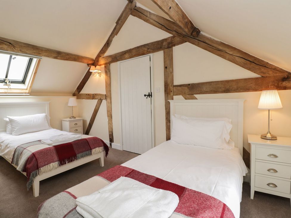 A bedroom with two beds and a window at The Old Barn in Hereford