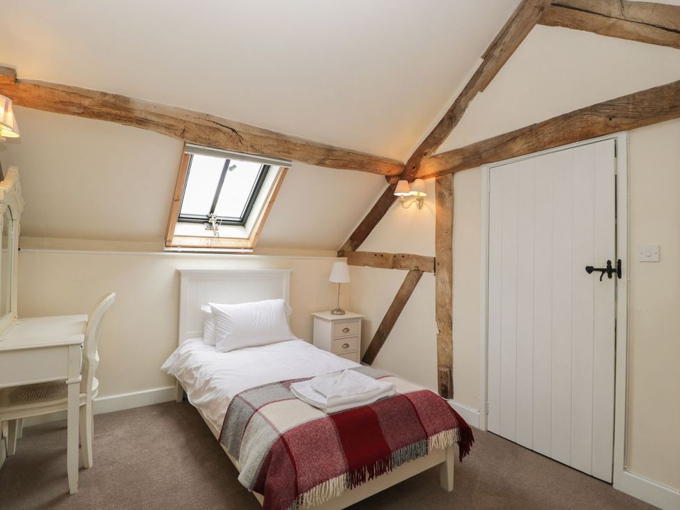 A bedroom with a single bed and desk at The Old Barn in Hereford