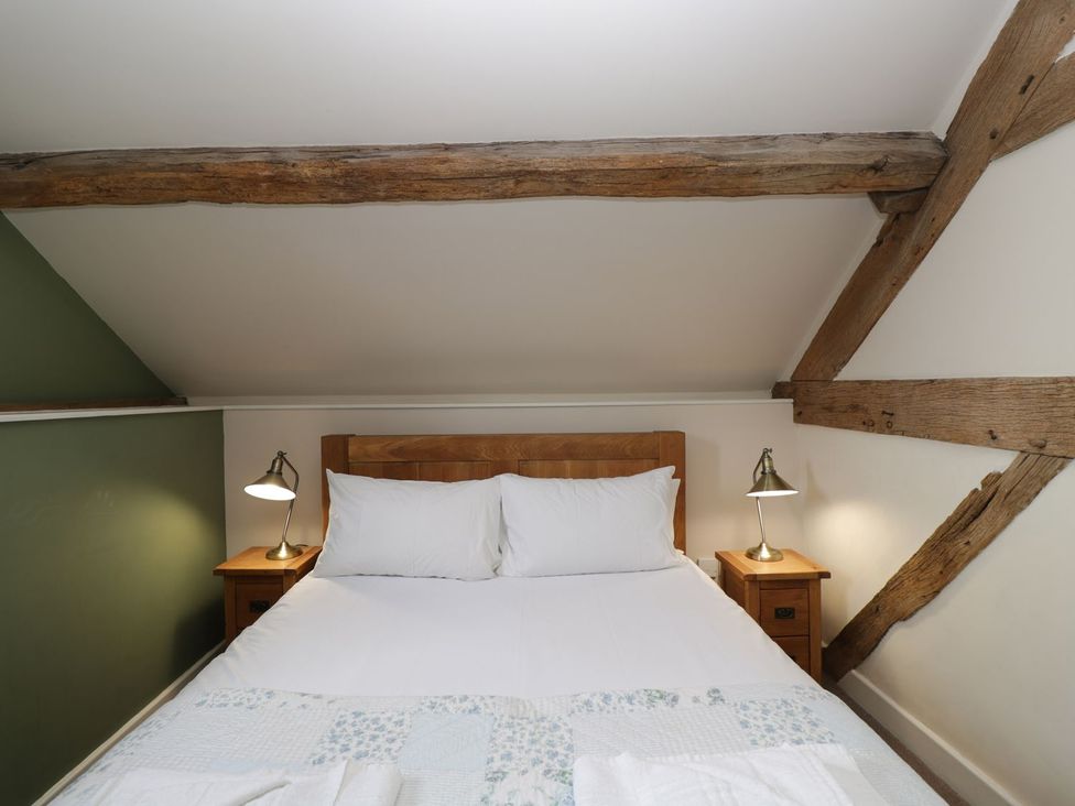 A bedroom with a bed and two lamps at The Old Barn in Hereford