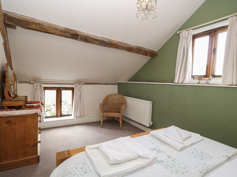 A bedroom with a bed and chairs at The Old Barn in Hereford