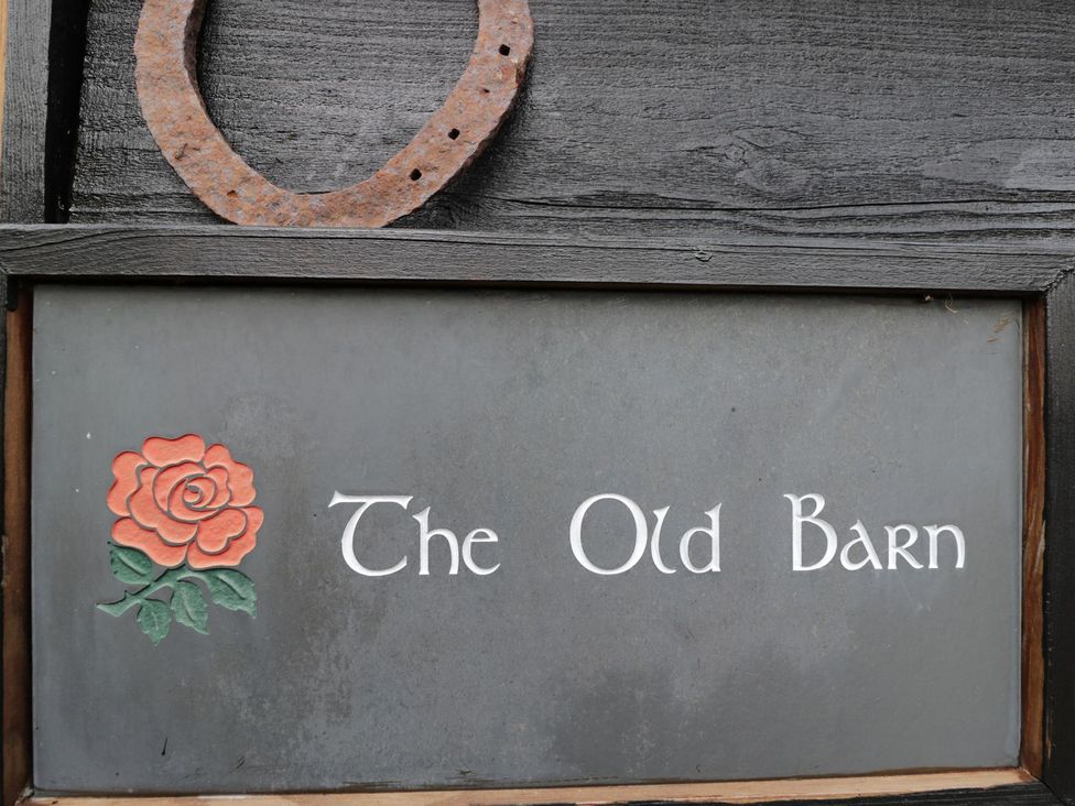 A sign featuring The Old Barn and a rose at The Old Barn in Hereford