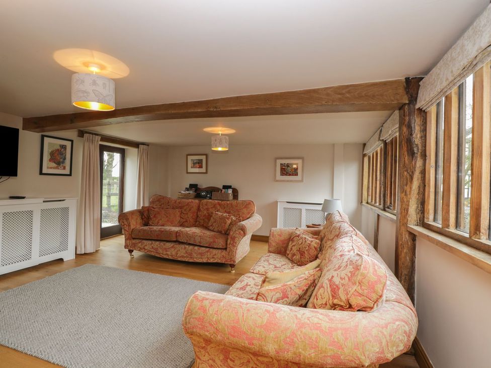 A living room with sofas and a television at The Granary in Hereford