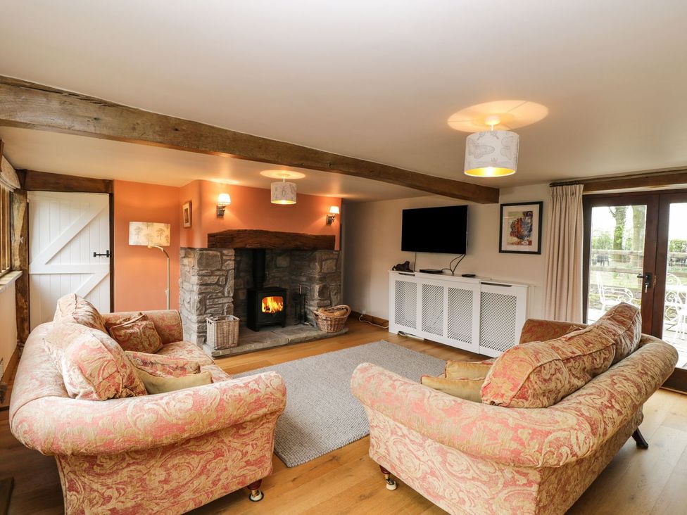 A living room with a fireplace and television at The Granary in Hereford