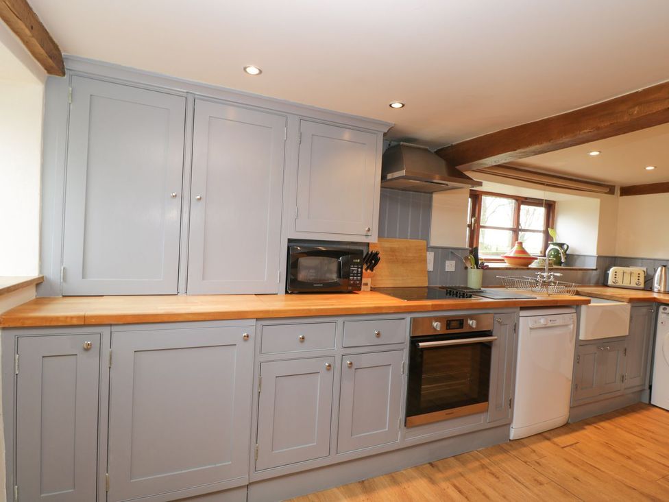 A kitchen with cabinets, a microwave, an oven, a sink, and a dishwasher at The Granary in Hereford