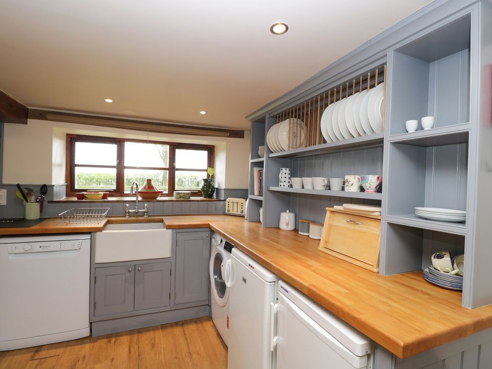 A kitchen with a sink and shelves at The Granary in Hereford