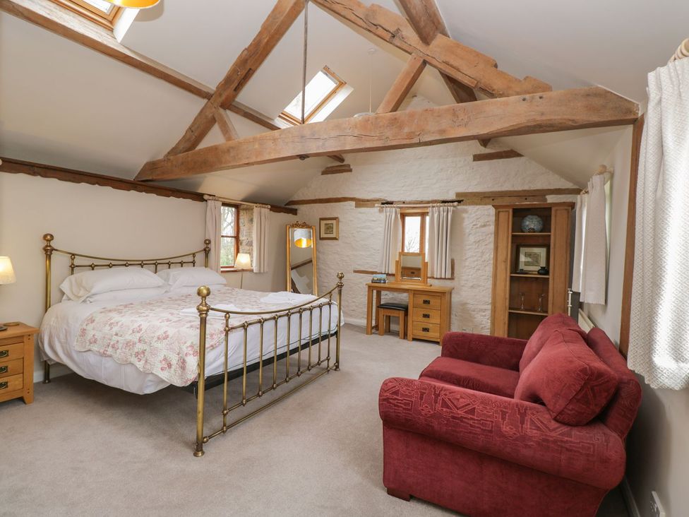 A bedroom with a bed, side tables, and a sofa at The Granary Hereford