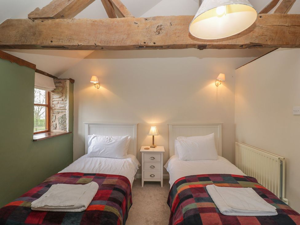 A bedroom with two beds and a window at The Granary in Hereford