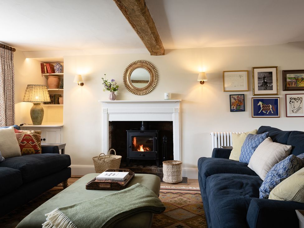 A living room with a sofa and fireplace at Ambersham House in Midhurst