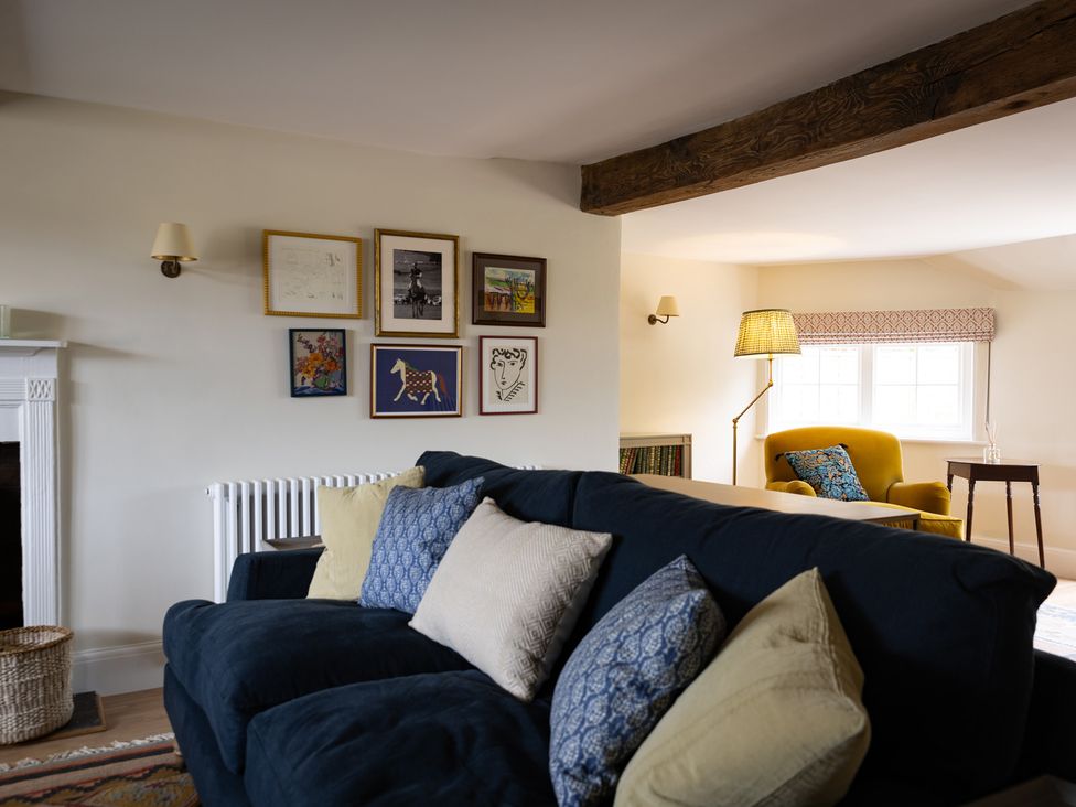 A living room with a sofa and artworks on the wall at Ambersham House in Midhurst