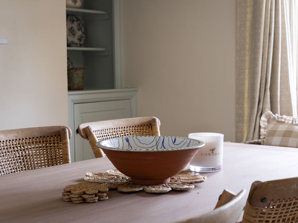 A dining room with a bowl and a candle on the table at Ambersham House in Midhurst