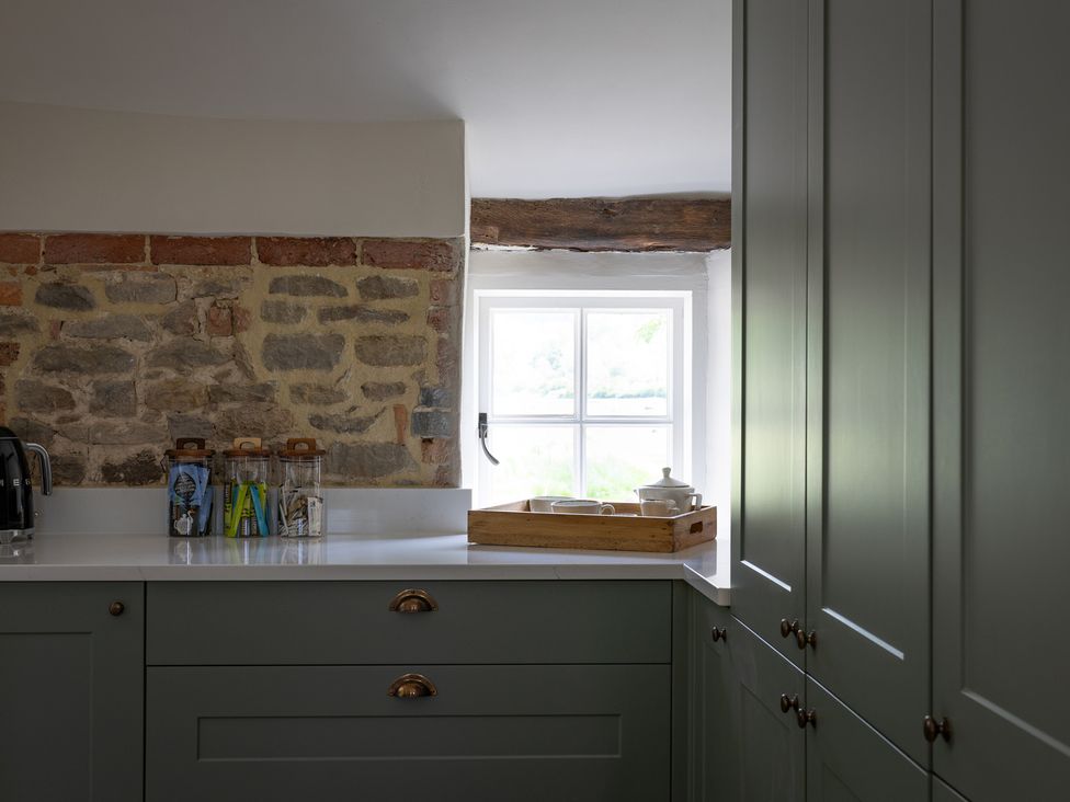 A kitchen with cabinets and storage jars at Ambersham House in Midhurst