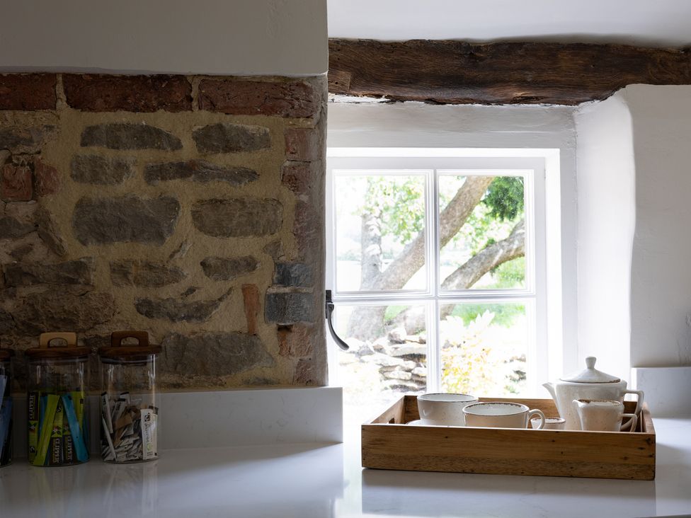 A kitchen with a window and ceramic dishes on a tray at Ambersham House in Midhurst