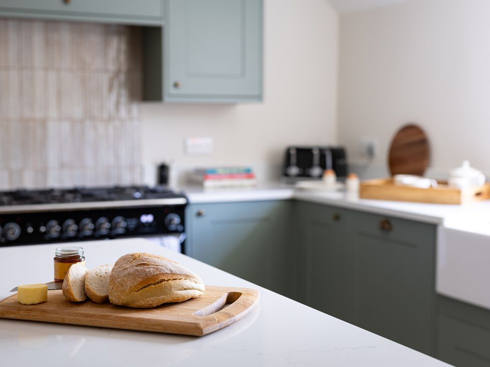 A kitchen with bread and butter on a cutting board at Ambersham House in Midhurst