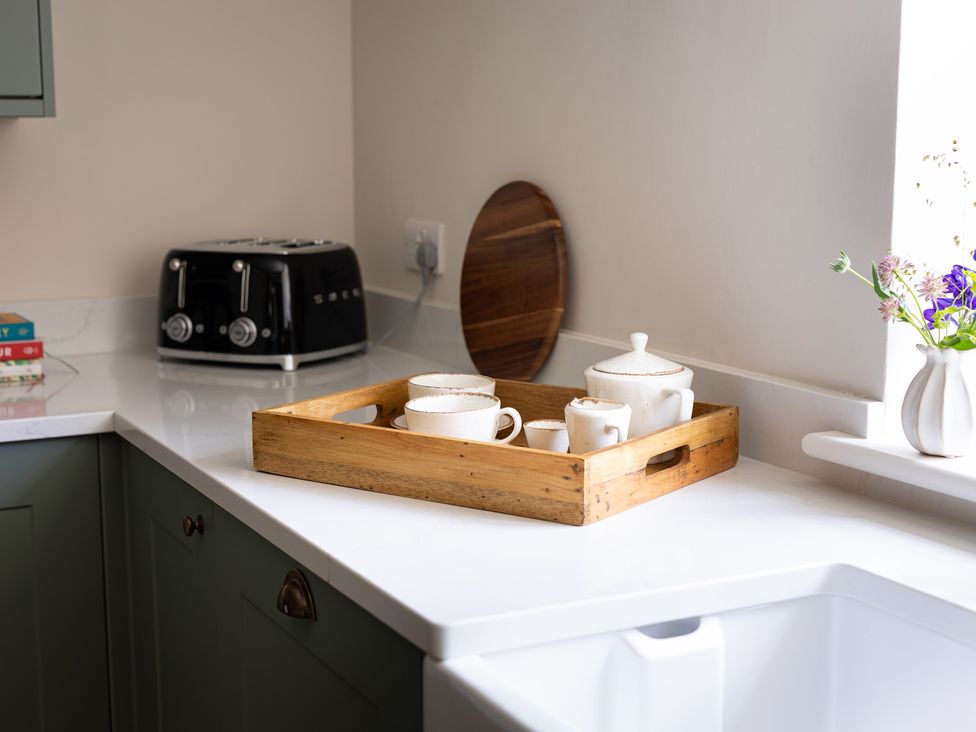 A kitchen with a wooden tray holding teapot and mugs at Ambersham House in Midhurst