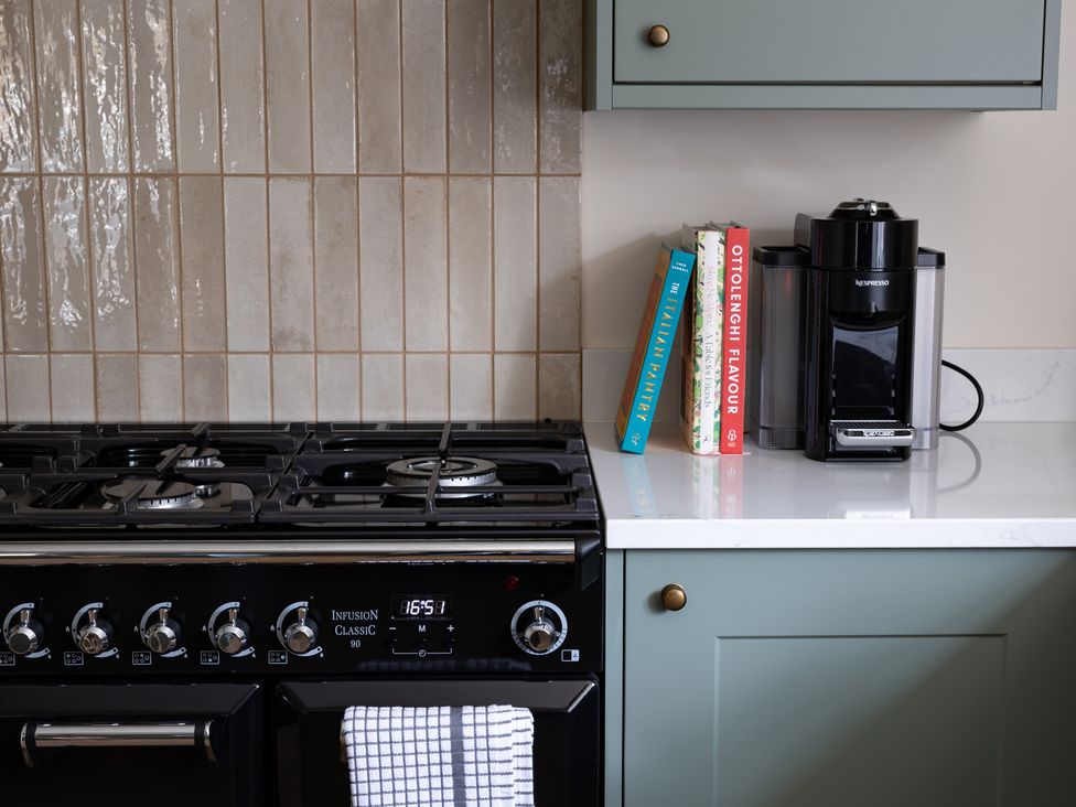 A kitchen with a stove and coffee maker at Ambersham House in Midhurst