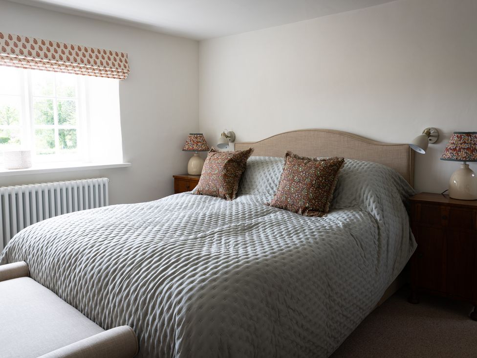 A bedroom with a bed and bedside table at Ambersham House in Midhurst