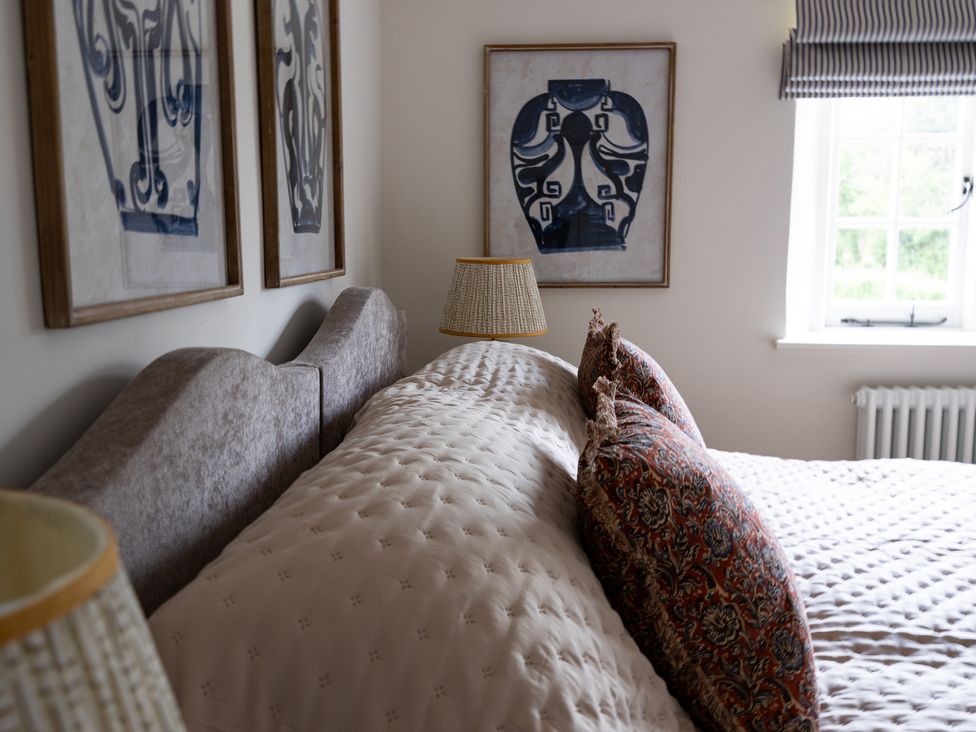 A bedroom with a bed and wall art at Ambersham House in Midhurst