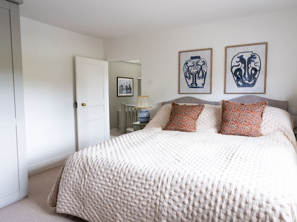 A bedroom with a double bed and art on the wall at Ambersham House in Midhurst