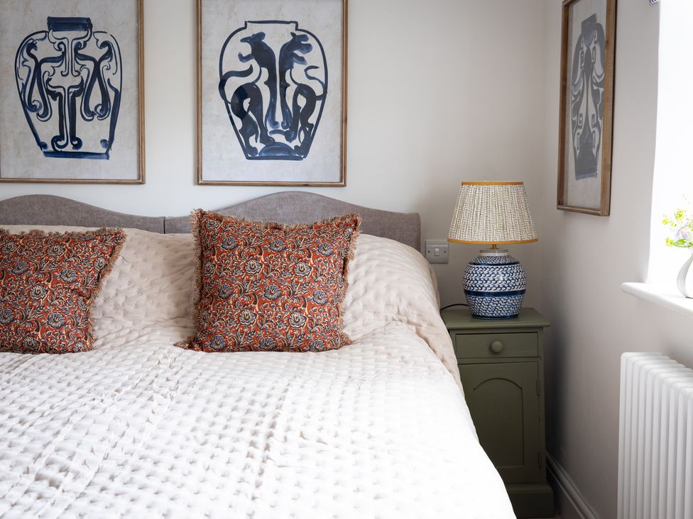 A bedroom with a bed and decorative pillows at Ambersham House in Midhurst