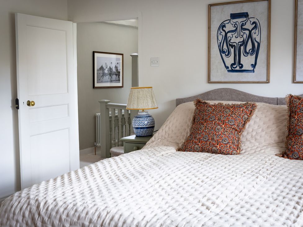A bedroom with a bed and decorative pillows at Ambersham House in Midhurst