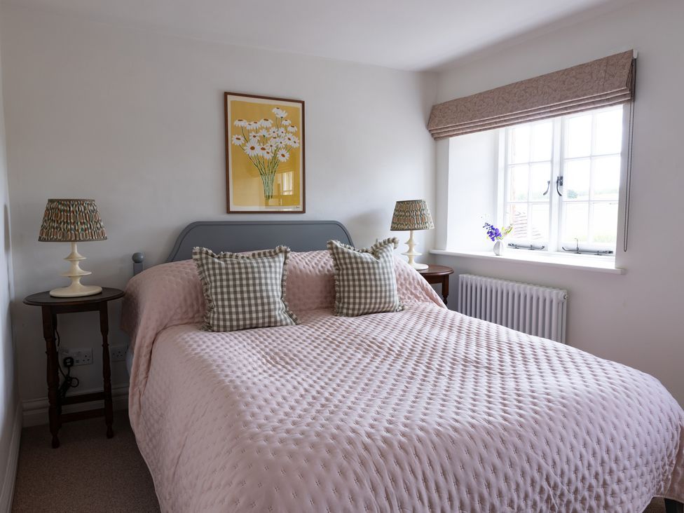 A bedroom with a bed and lamps at Ambersham House in Midhurst