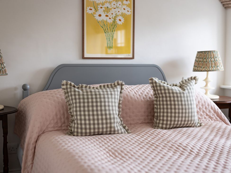 A bedroom with a bed and decorative pillows at Ambersham House in Midhurst