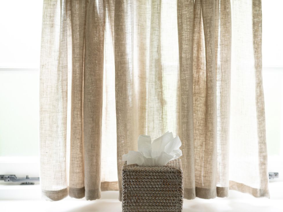 A tissue box with tissues next to curtains at Ambersham House in Midhurst