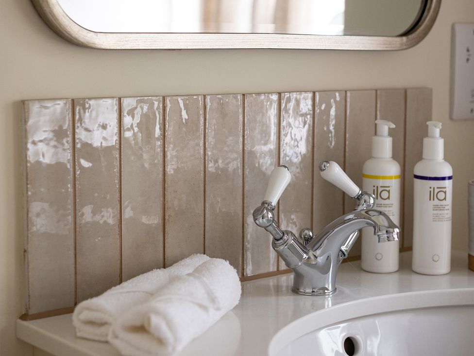 A sink with a faucet and soap dispensers at Ambersham House in Midhurst