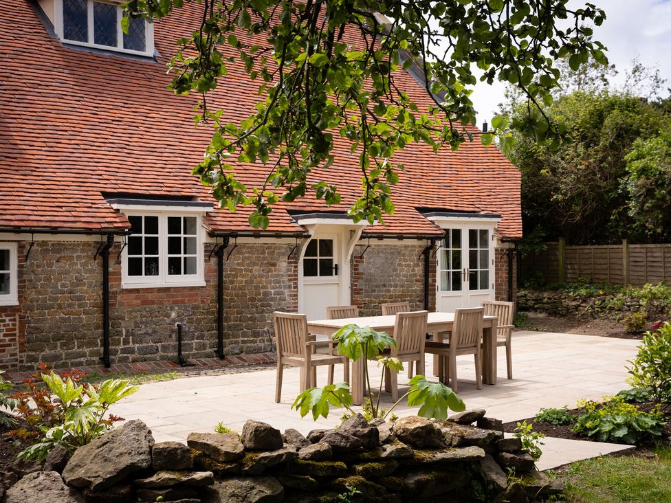 A garden with a table and chairs at Ambersham House in Midhurst