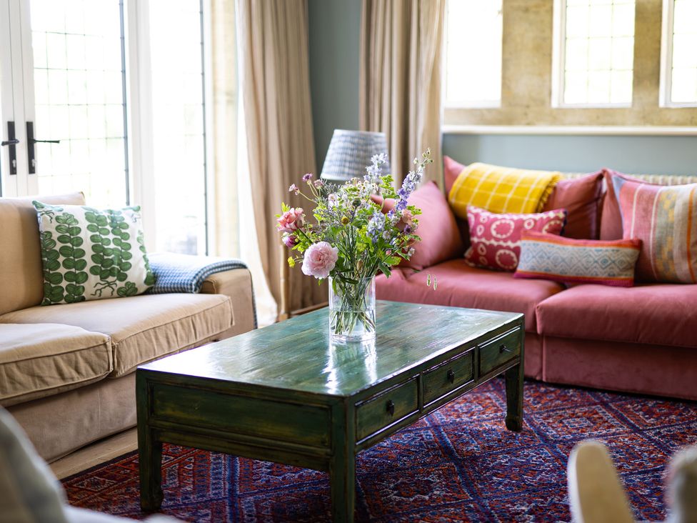 A living room with a coffee table and flower arrangement at Costers Lodge in Midhurst
