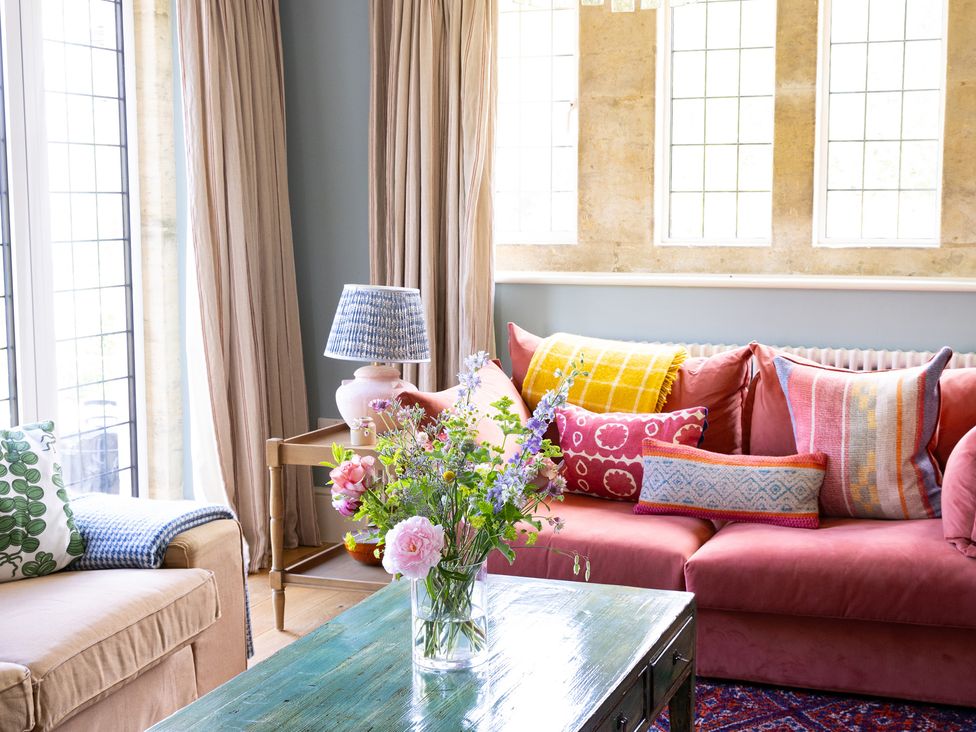 A living room with a sofa, cushions and a coffee table at Costers Lodge in Midhurst