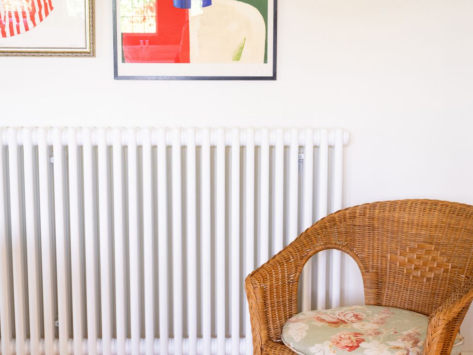 A sitting room with a radiator and a chair at Costers Lodge in Midhurst