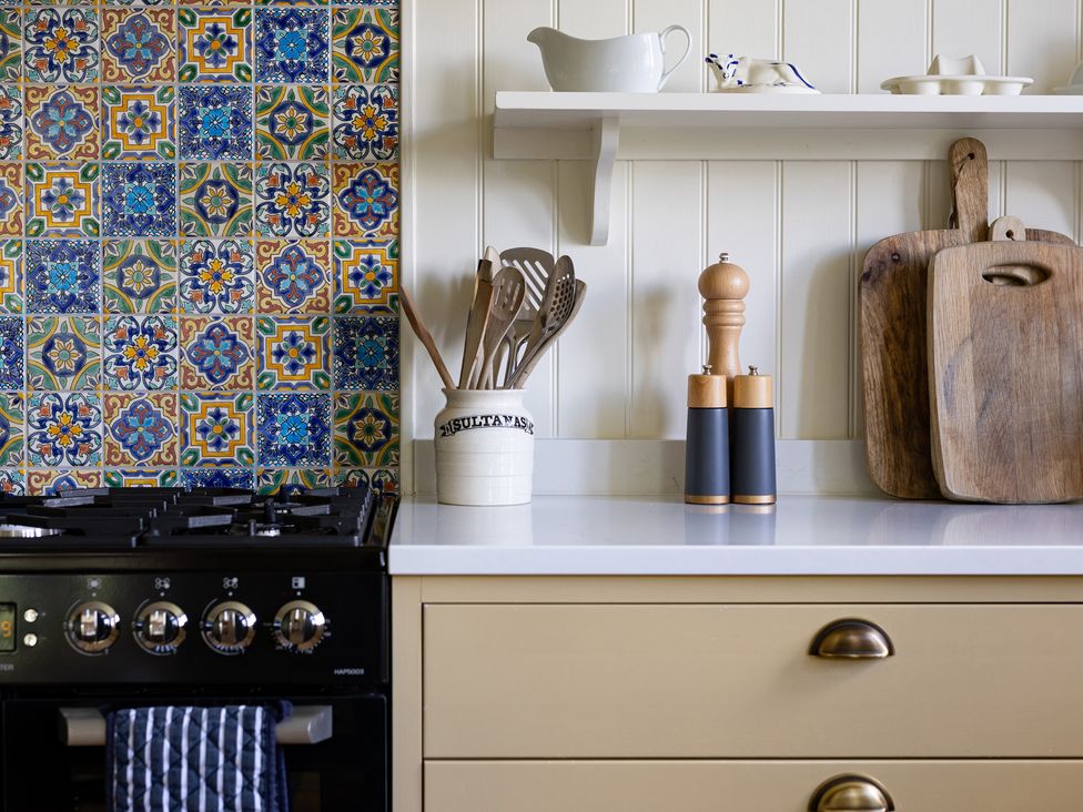 A kitchen with a stove and utensils on a counter at Costers Lodge in Midhurst