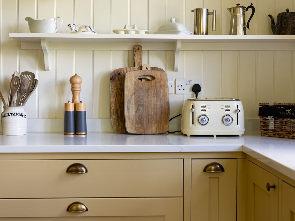 A kitchen with a toaster and wooden cutting board at Costers Lodge in Midhurst