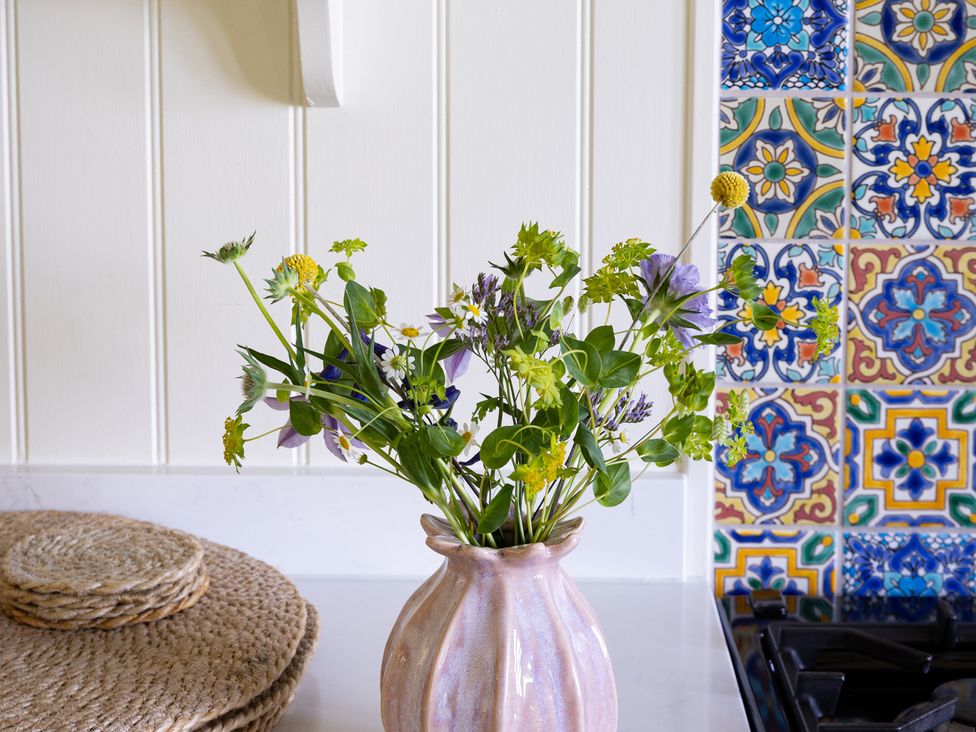 A vase with flowers on a kitchen counter at Costers Lodge in Midhurst