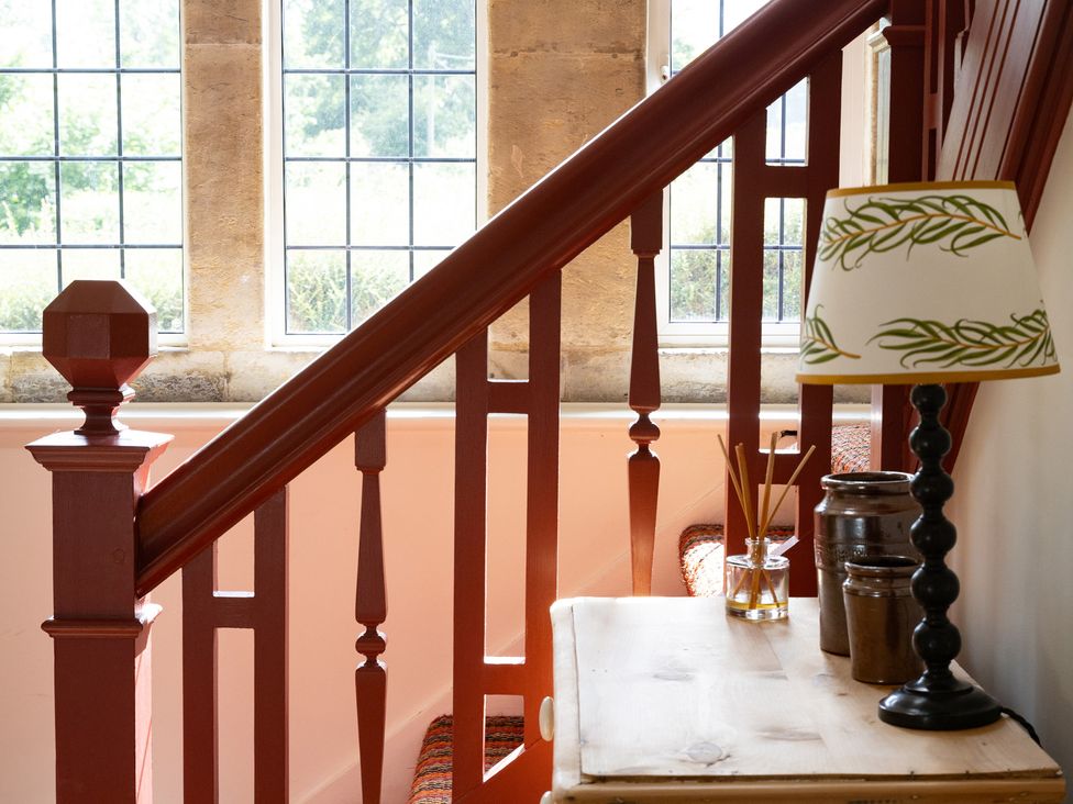 A staircase with a handrail and a table beside it at Costers Lodge in Midhurst