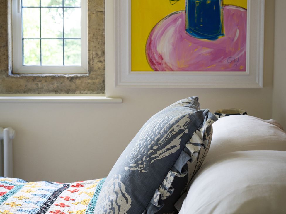 A bedroom with a bed and artwork on the wall at Costers Lodge in Midhurst