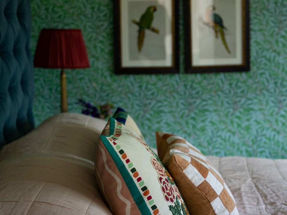 A bedroom with pillows on a bed and wall art at Costers Lodge in Midhurst