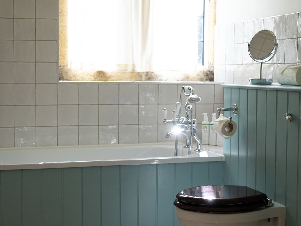 A bathroom with a bathtub and toilet at Costers Lodge in Midhurst