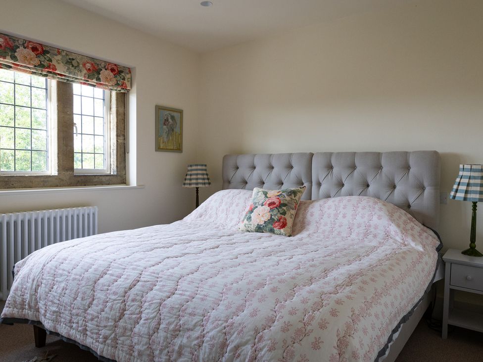 A bedroom with a bed and window at Costers Lodge in Midhurst